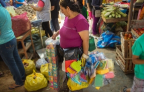 This woman carries around lots of little knick knacks and sells them to people in the market.
